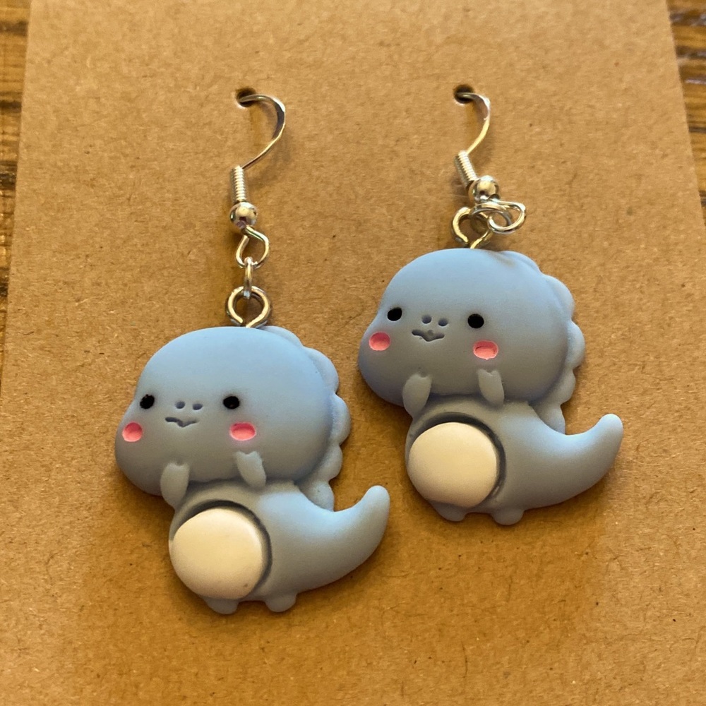 Homemade dinosaur earrings fish hook wires.